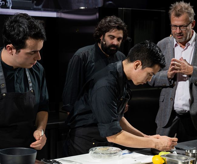 © Madrid Fusión Konstantin Filippou mit seinen Souschefs und Moderator Wolfgang Schedelberger